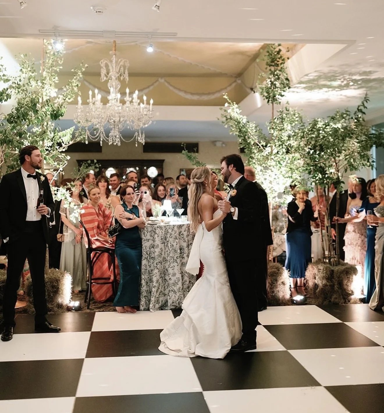 Chandelier lit reception space with a checkered dance floor set up for a San Francisco event